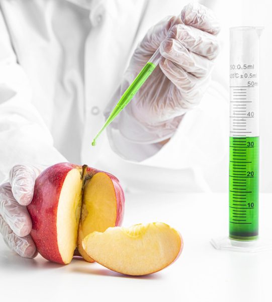 person-injecting-apple-with-green-chemicals person-injecting-apple-with-green-chemicals